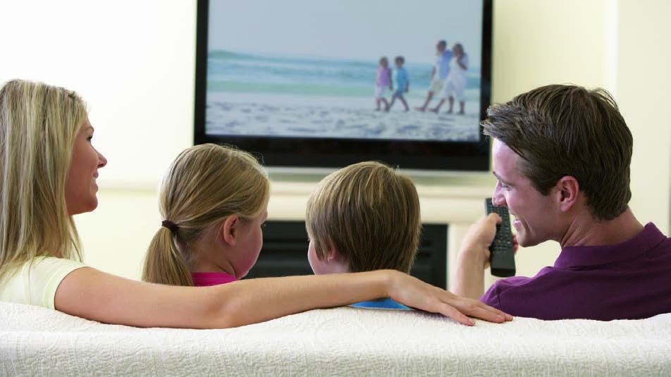 Familie im Wohnzimmer vor dem Fernseher